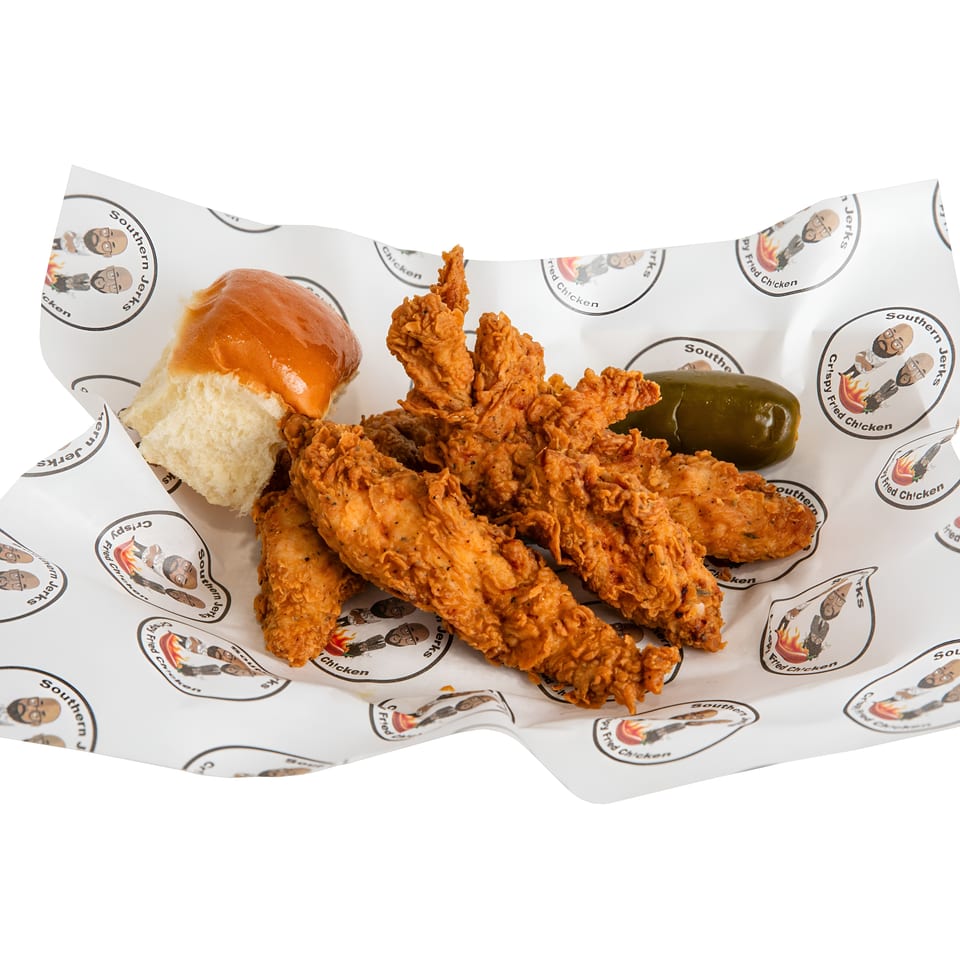 Crispy fried chicken tenders served with a soft bun and whole green pepper on branded Southern Jerks paper.